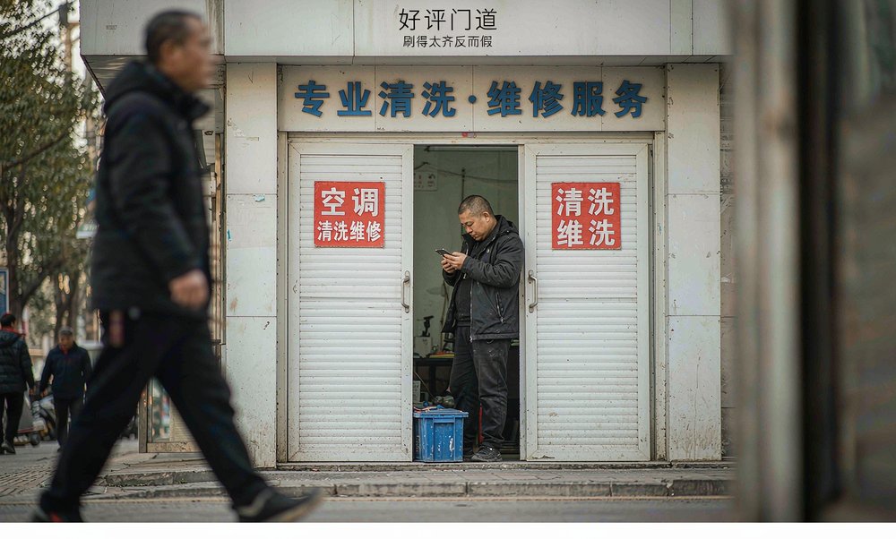 家电清洗门店老板在门口看手机评价,好评刷得太齐反而是信号