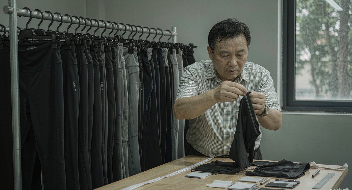 样品间里挂满瑜伽裤样衣,卷尺和面料小样摆在桌上